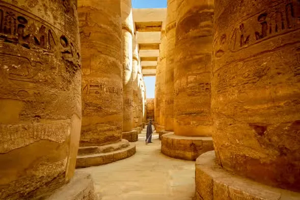 Rows of tall carved stone columns inside a temple complex at Luxor, Egypt